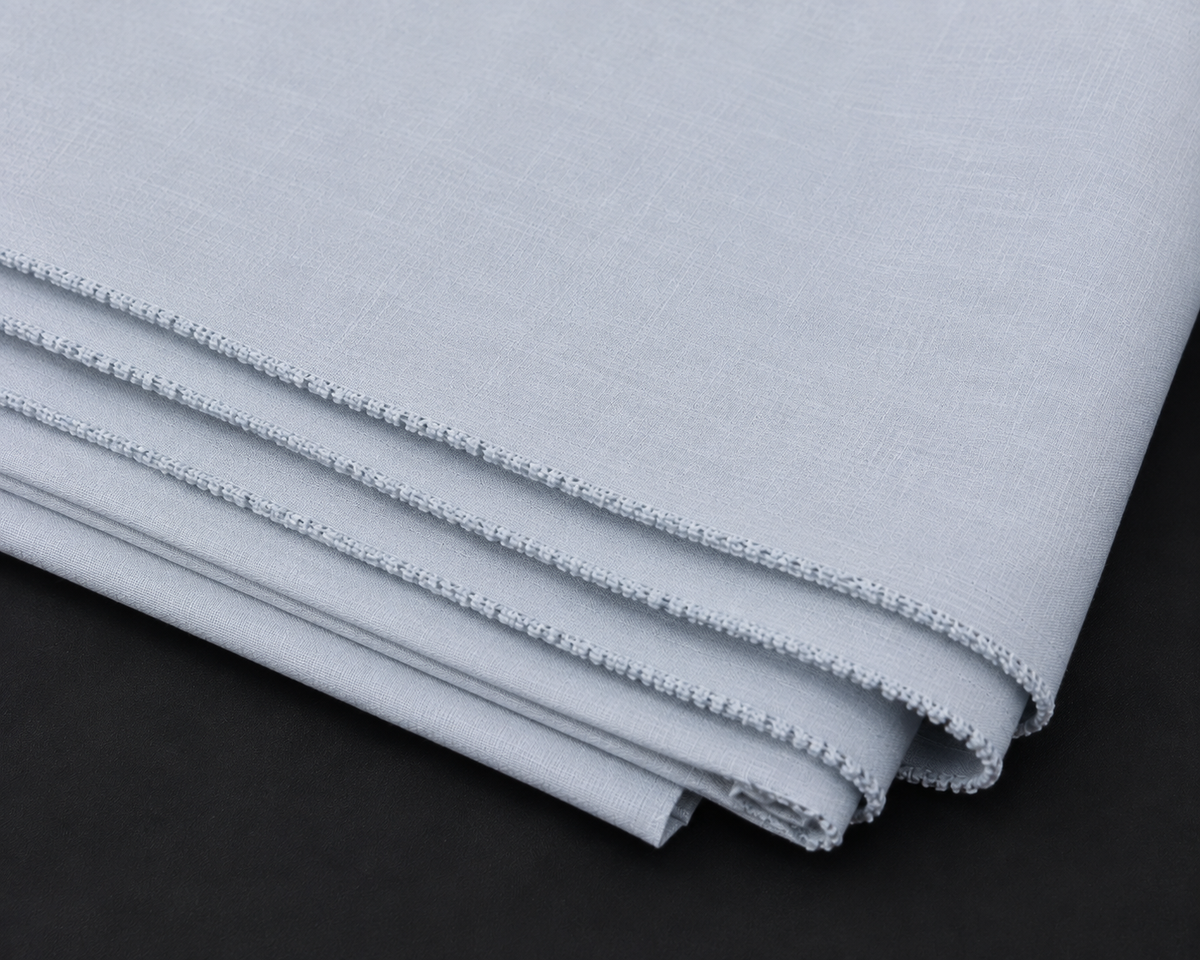 A folded piece of light gray fabric with a textured weave and decorative zigzag stitched edges, displayed on a dark background.