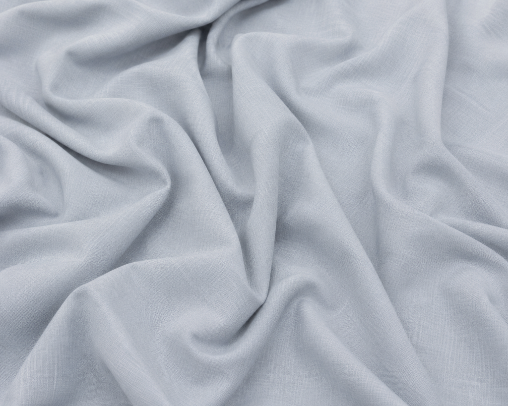 Light gray textured fabric with soft draped folds and a woven linen-like surface.